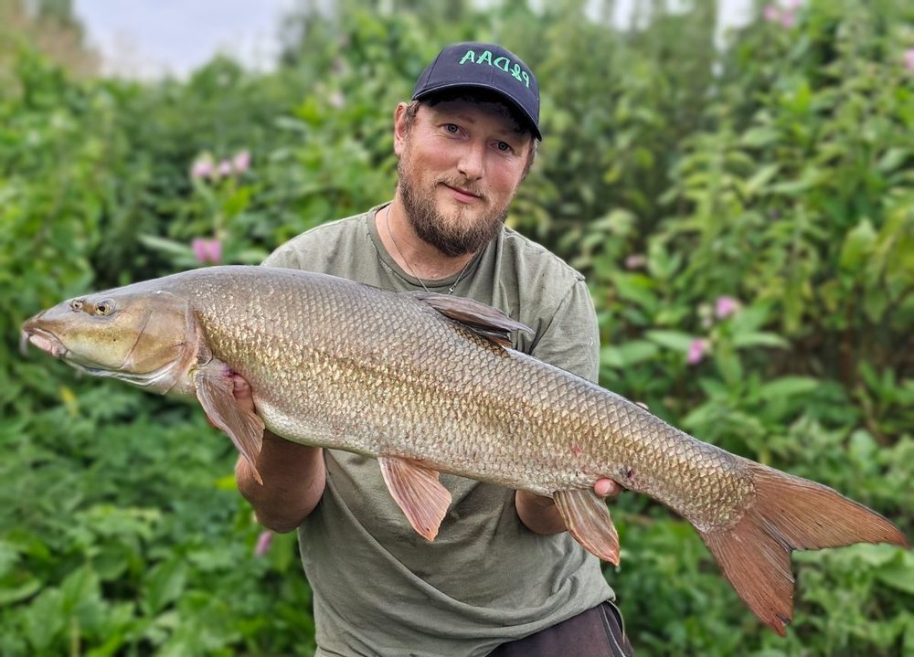 Robbie Cunnington holding a 12lb 14oz barbel at Elton Fishery